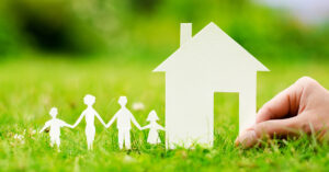 Cutouts of home and family sitting on grass